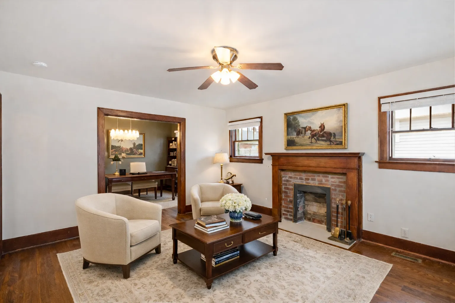 Living room with brick fireplace opening into a custom study