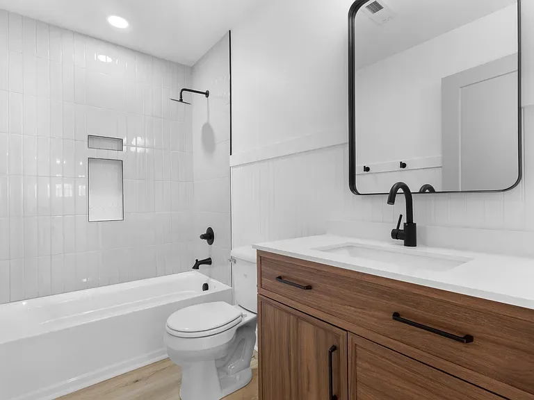 Bathroom with walnut vanity and matte black fixtures